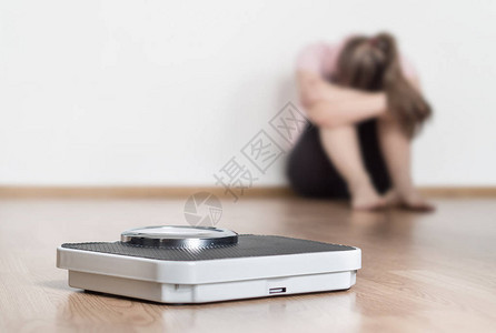 规模和沮丧沮丧和悲伤的女人坐在地板上图片