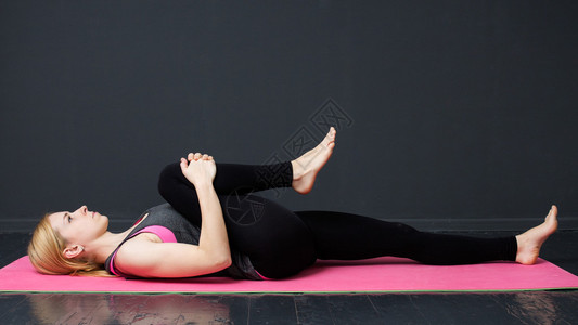 健身图片瑜伽健身年轻女子正在垫子上做瑜伽锻炼背景