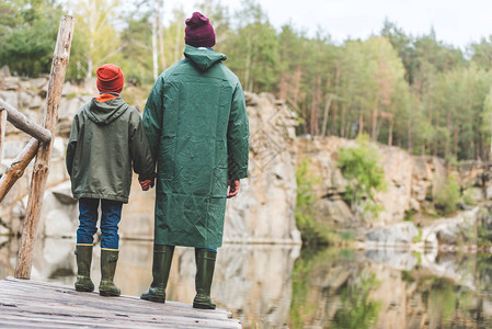 父亲和儿子在森林桥上站着时图片
