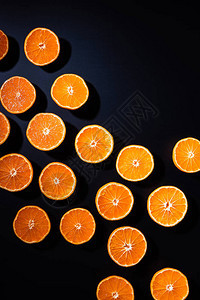黑色背景上排列整齐的橘子两半的完整框架图片