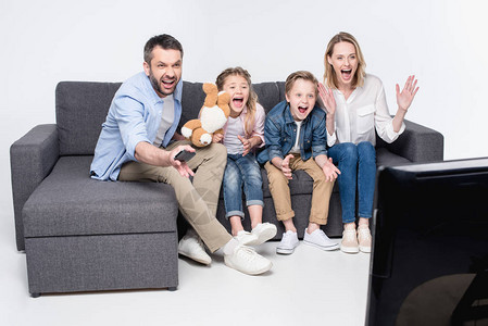 兴奋的家人一起坐在沙发上看电视图片