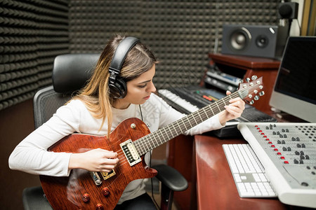 在录音室弹吉他的女音乐家图片