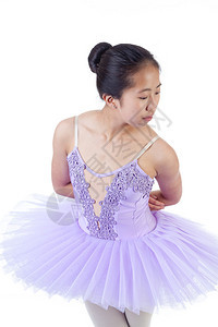 年轻的亚洲芭蕾舞者穿着紫色的塔图和尖鞋跳舞图片