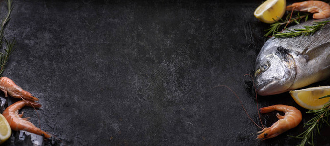 在垃圾纹理黑色背景设计上的新鲜海成分的顶部视图质朴的深色石板上的虾鲷鱼香草柠檬和冰块图片