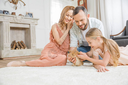家庭快乐在家的白地毯上玩着图片