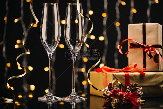 两个空葡萄酒杯节日丝带和包着的圣诞礼图片