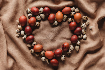 亚麻桌布上的心形复活节彩蛋和鹌鹑蛋图片