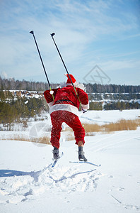 圣诞老人在冬季森林滑雪图片
