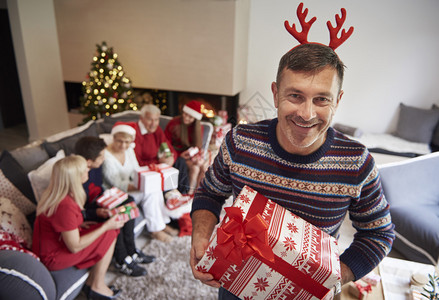 快乐的父亲在圣诞节家庭庆典上带着礼图片