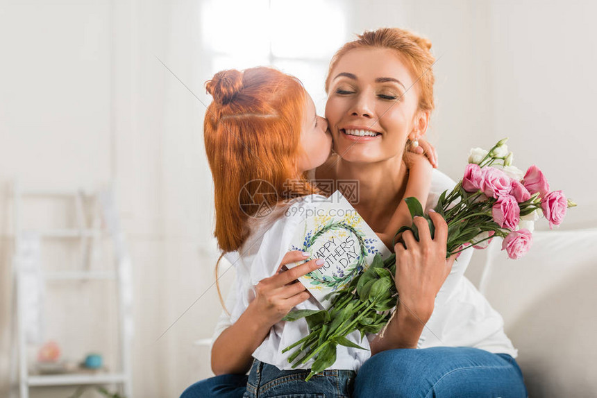 可爱的女孩在母亲节在家用花束和明图片