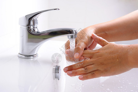 在浴室里用流动的自来水洗手图片