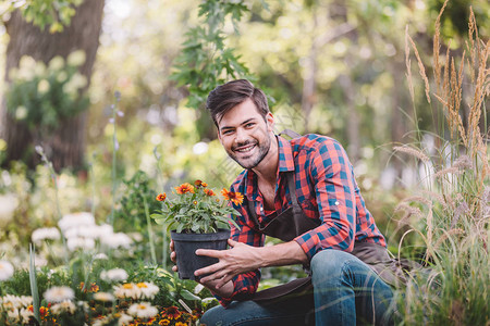 微笑的园丁肖像手握花盆看着图片