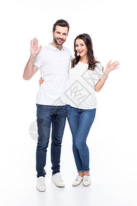 美丽的年轻微笑的情侣挥舞着双手在白图片