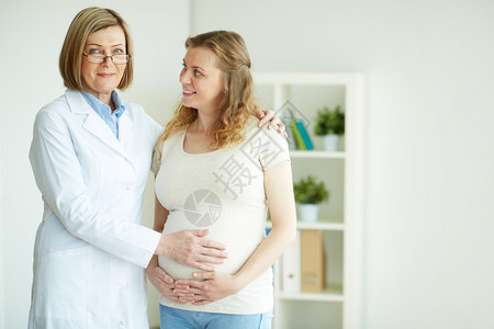 孕妇和医生在医院定期检查后快乐的怀孕图片