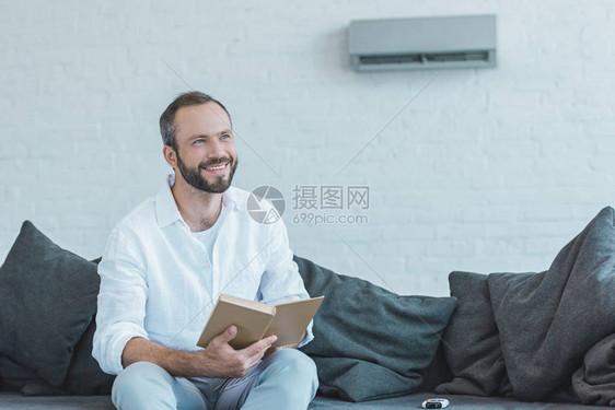 面带书的笑着胡子的男人坐在沙发上墙图片