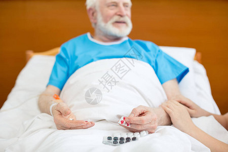 在医院床上微笑的老年病人持有图片