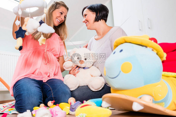 孕妇及其朋友为婴儿准备育婴图片
