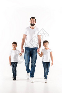 年轻父亲和孩子手牵一起走在白色的孤图片