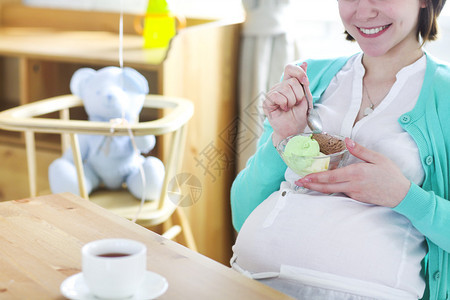 快乐的孕妇吃冰淇淋特写图片