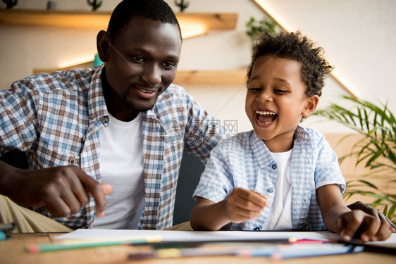 快乐的非裔美国父亲和儿子在咖啡馆一图片