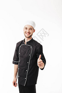 穿着黑色制服的年轻笑男人厨师欢喜地看着镜头在白色背图片