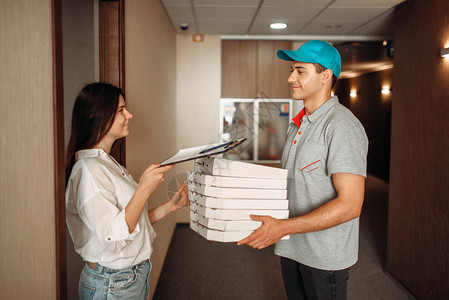 女顾客从送披萨的快递服务处接送比萨饼的男孩处订货图片