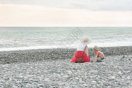 妈和儿子坐在沙滩上看着大海图片
