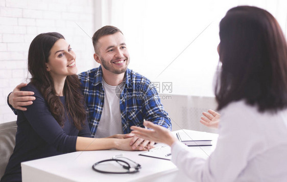 家庭医疗婚姻幸福的一对夫妇在预约时听医生讲图片