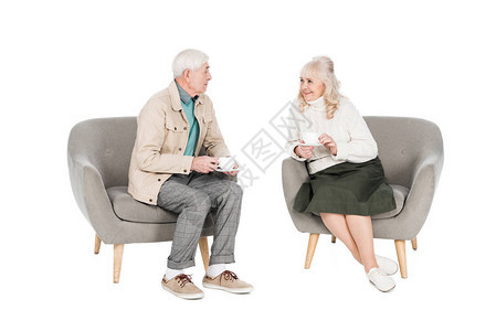 幸福快乐的退休丈夫看着妻子拿着茶杯图片