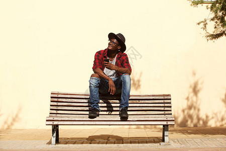 坐在街边的长椅上坐着顶帽子的非洲冷图片