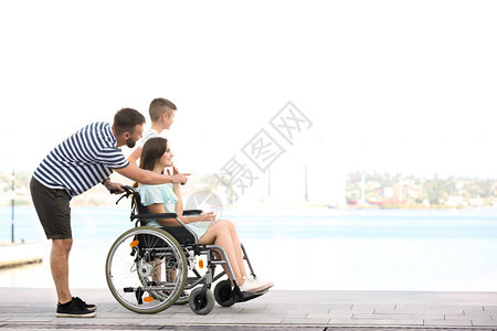 与家人一起在户外行走的坐在轮椅图片