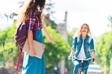 快乐学生在街上骑自行车时看图片