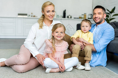 有两个孩子的幸福家庭与两个孩子一起坐在家中时图片