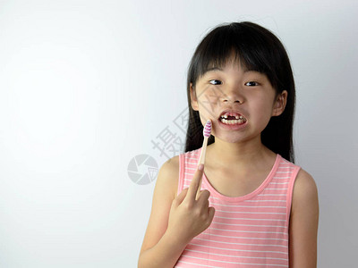 没有前牙的亚洲小女孩拿着牙刷图片