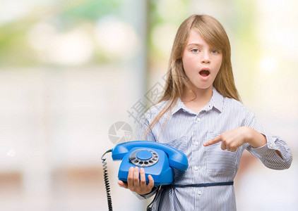 年轻金发小金发女孩拿着古老电话图片