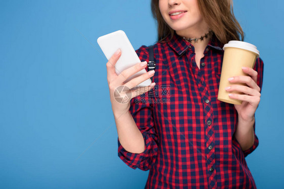 年轻女孩用智能手机喝咖啡的作物风景图片
