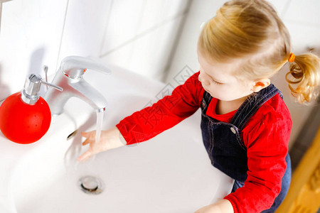 可爱的蹒跚学步的小女孩在浴室里用肥皂和水洗手可爱的孩子学习清洁身体部位早上的卫生习惯在家或托儿所快图片