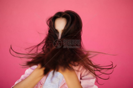 粉红背景的黑长发美女肖像被隔离在孤立处图片