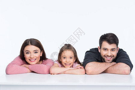 幸福的家庭一个孩子靠在白桌子上微笑图片