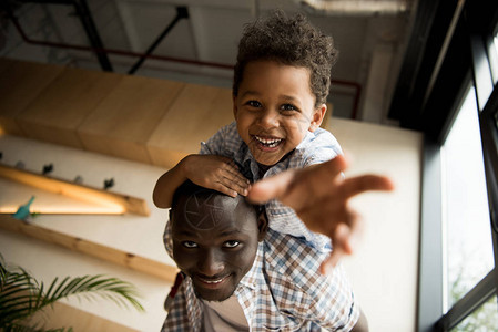 美丽的非洲快乐的美国父亲和孩子在镜头中拥抱和笑容图片