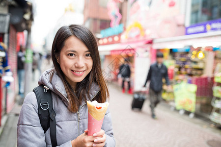 店铺原宿素材街边拿着绉饼的女人背景