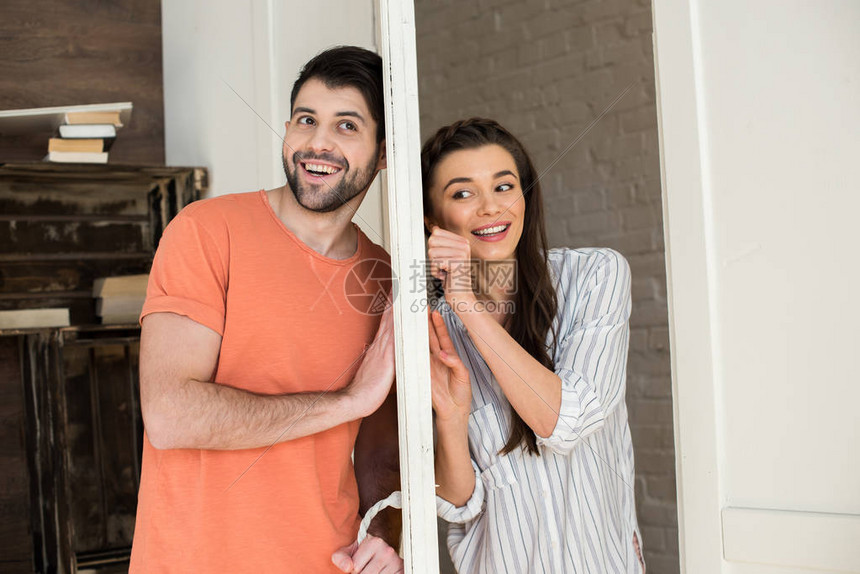 快乐的年轻夫妇在家中通过门图片