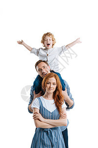 快乐的年轻父母和可爱的小儿子笑着看在白色上图片