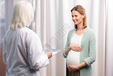 医生写下年轻孕妇在医疗咨询期间投诉的笔录图片