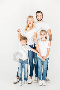 带着白色T恤的年轻快乐家庭站在一起笑着看镜头图片