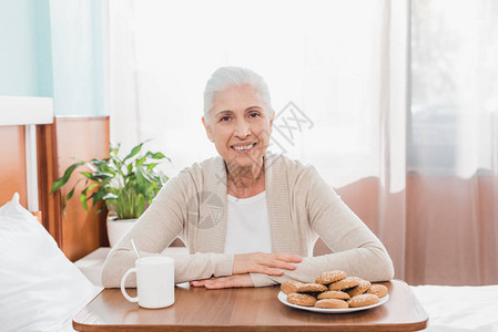 快乐的老女人在医院吃东西时图片