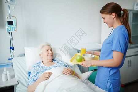 年轻护士为年长病人提供图片