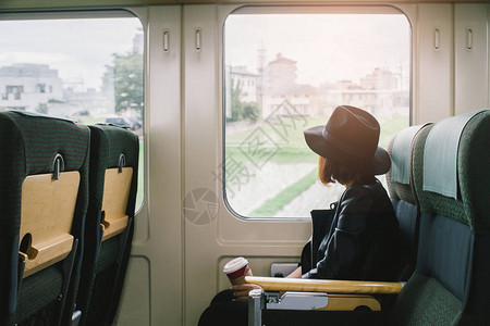年轻美女在日本经典列车旁旅行坐在窗户旁边的古董过滤器上图片