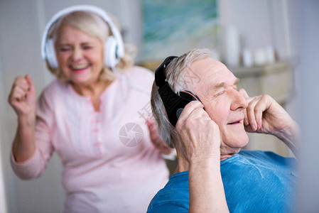 戴耳机的快乐老年夫妇在家玩得开心图片