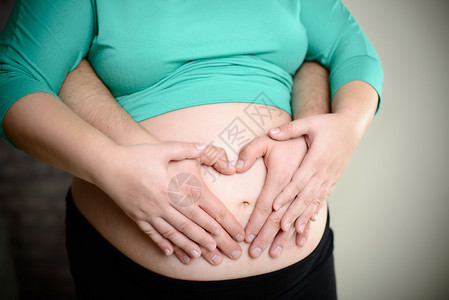 父母亲手握着怀孕的肚子他们将她们置图片